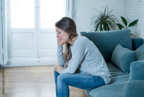 Young sad woman suffering from depression feeling desperate and lonely at home