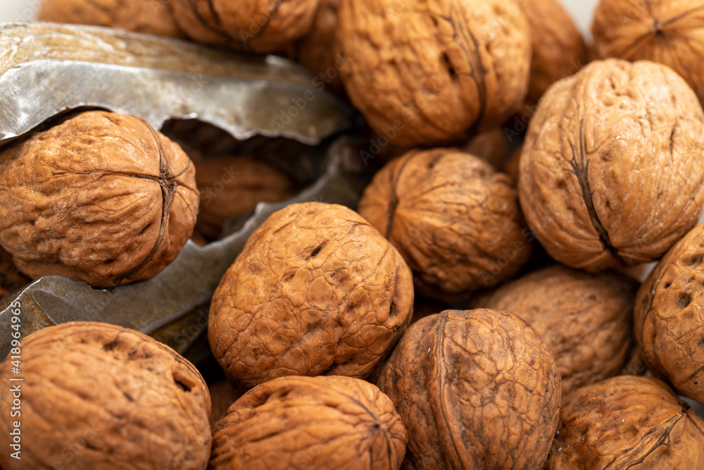 Close-up walnuts pile. Walnut cracker Close-up walnuts pile. Walnut cracker