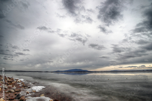 MIETKOW, POLAND - FEBRUARY 03, 2021: An ice-covered beach by the Mietkowski Lagoon, with the Sleza Mountain in the background. Mietkow near Wroclaw, Poland, Europe. photo