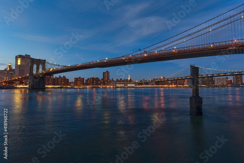 scene of New york Cityscape with Brooklyn Bridge over the east river at the twilight time, USA downtown skyline, Architecture and transportation concept