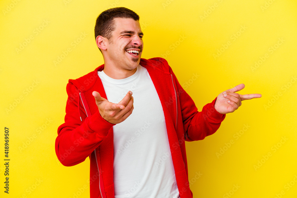 Young caucasian cool man isolated on yellow background joyful laughing a lot. Happiness concept. Young caucasian cool man isolated on yellow background joyful laughing a lot. Happiness concept.