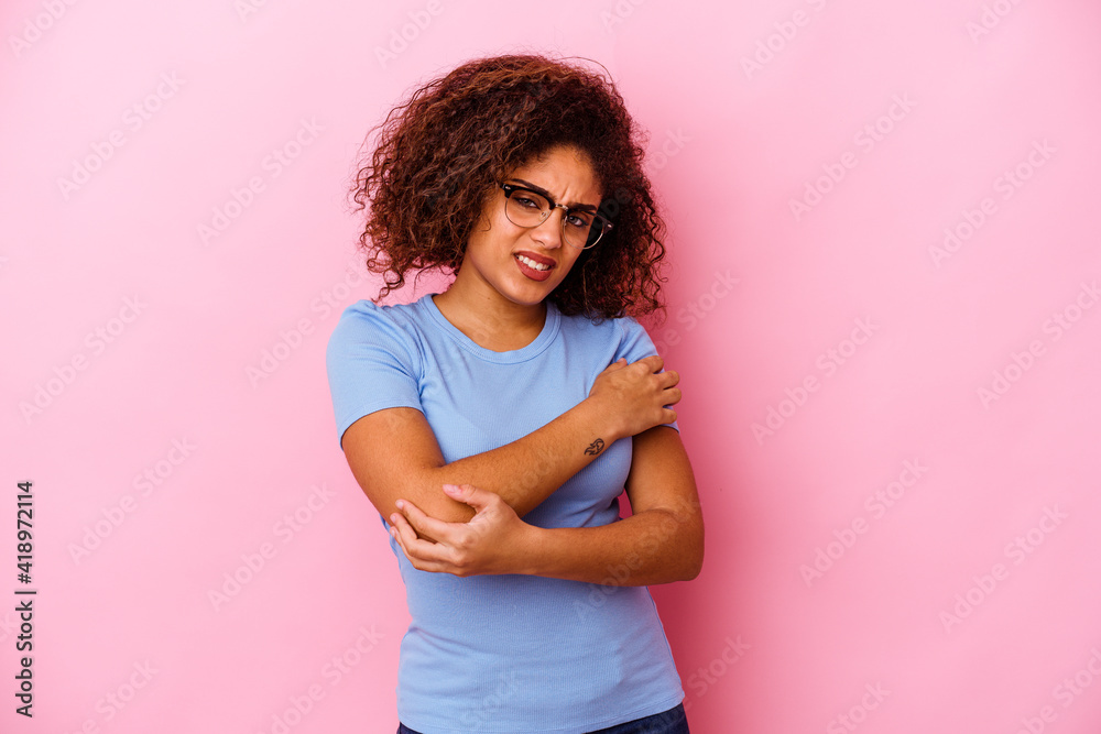 Young african american woman isolated on pink background massaging elbow, suffering after a bad movement. Young african american woman isolated on pink background massaging elbow, suffering after a bad movement.