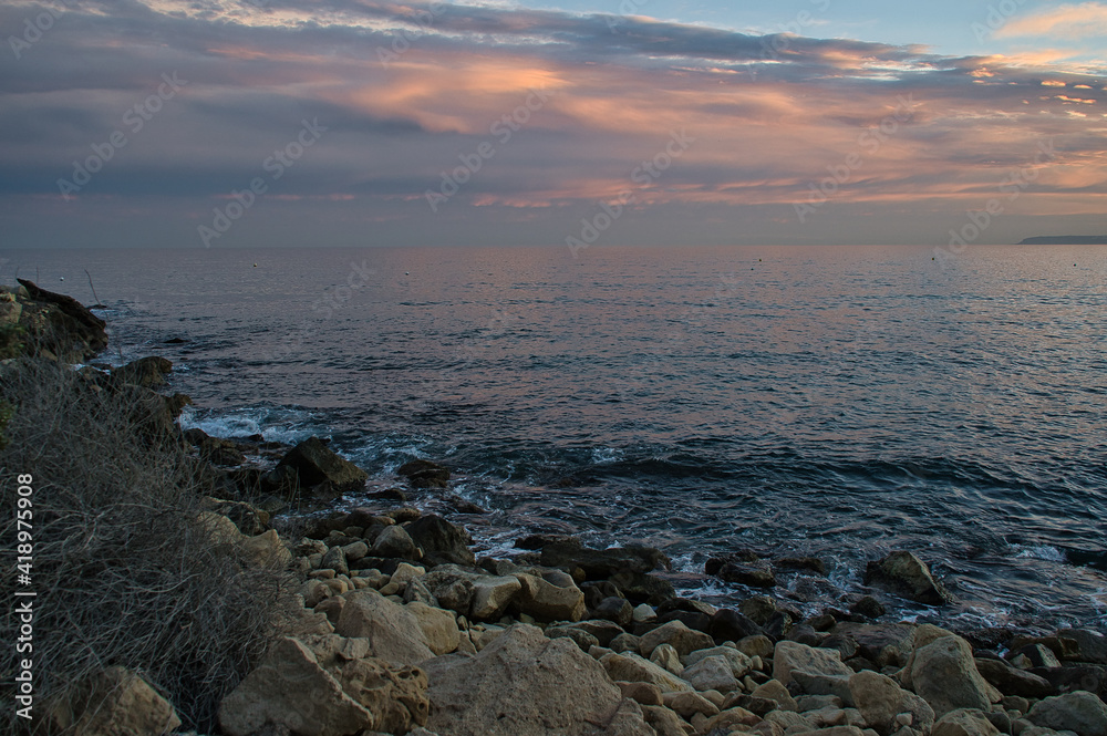 Sea waves lash line impact rock on the beach, located in Alicante