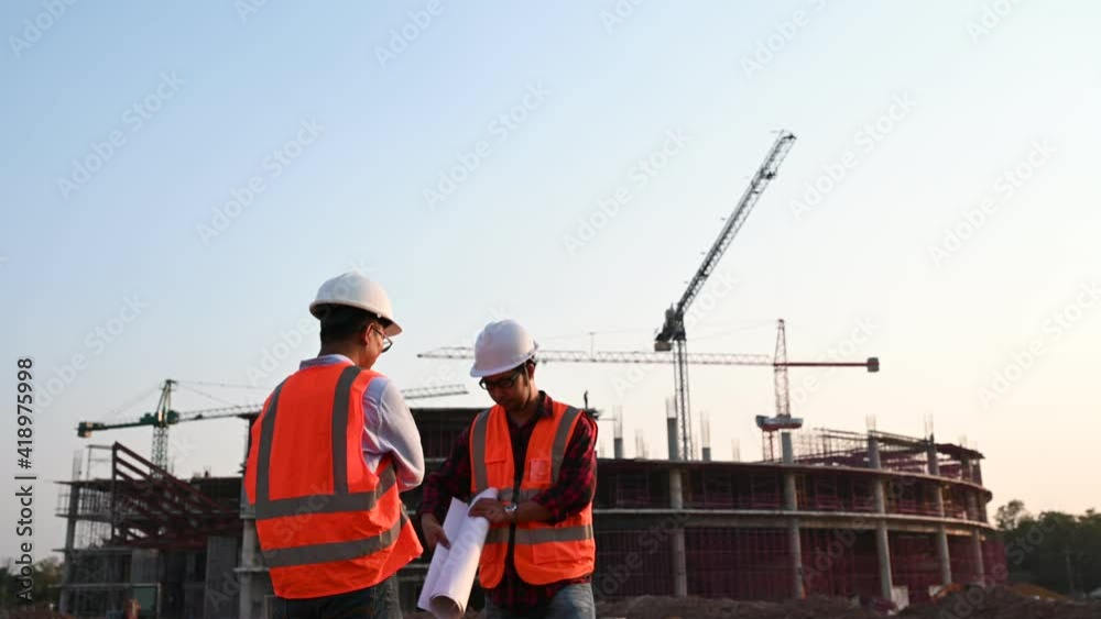Two Asian engineer working at site of a large building project,Thailand people,Work overtime at construction site,Team of engineer discus at site Two Asian engineer working at site of a large building project,Thailand people,Work overtime at construction site,Team of engineer discus at site