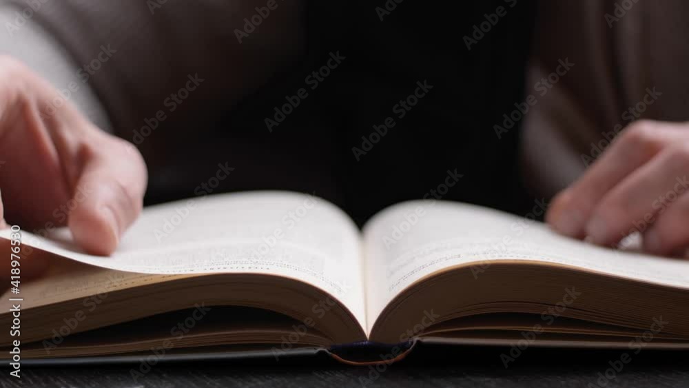 Unrecognizable person reading a book. Hand Turning Pages of a Book, close up. Unrecognizable person reading a book. Hand Turning Pages of a Book, close up.