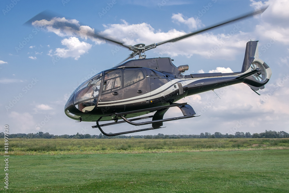 Take off the helicopter from the grass airfield.