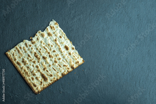 Piece of matzah bread for Jewish holiday Pesach or Passover on marble background with copy space. photo