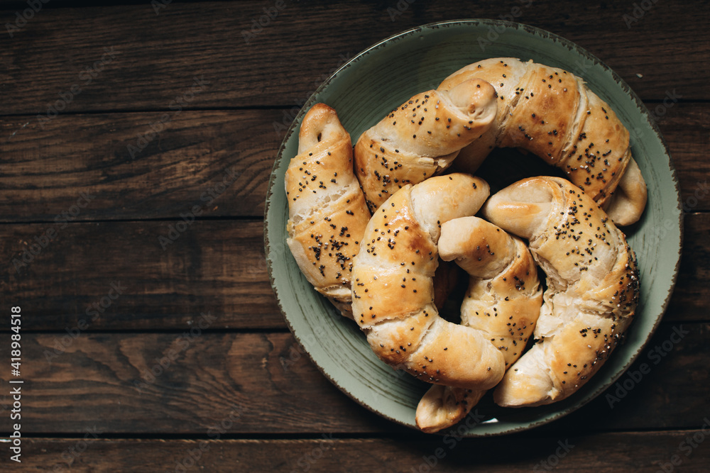 Freshly baked homemade croissants on wooden table. Selective focus. Fresh out of the oven. Breakfast or brunch concept. Freshly baked homemade croissants on wooden table. Selective focus. Fresh out of the oven. Breakfast or brunch concept.
