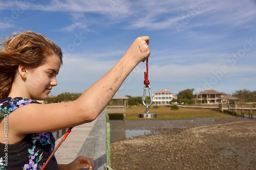 Girl magnet fishing on a pier