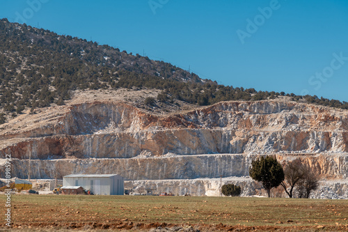 Rock quarry mining for gravel and limestone with blast marks showing on the sides of steep walls