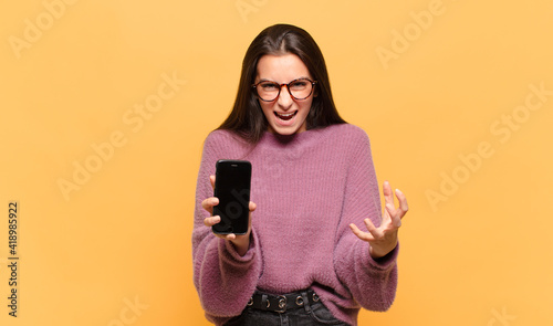 Fotografie young pretty woman looking desperate and frustrated, stressed, unhappy and annoyed, shouting and screaming