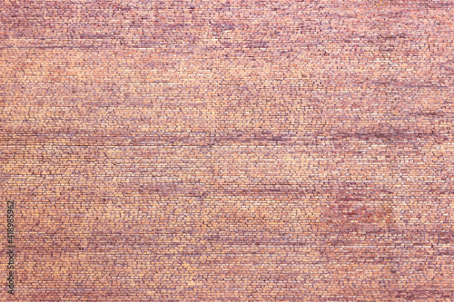 A huge solid brick wall with no windows. Old, cracked masonry, coated with deposits and grime.