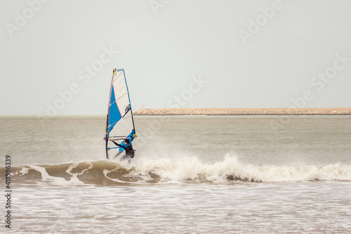 Man practicing windsurfing on the beach of the coast of Cádiz, Spain.