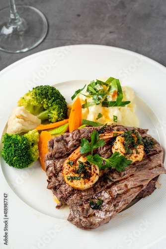 Delicious juicy grilled steak and shrimp with grilled broccoli and cauliflower. Surf and Turf style.
