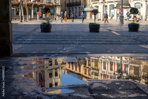 busy Zocodover Square in Toledo with reflections in a puddle of water in the foreground photo