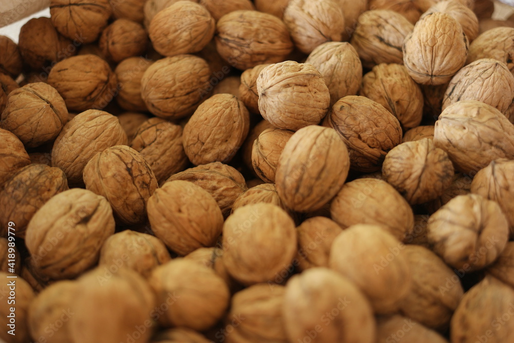 Pile of walnuts at the farmers market. Close up of walnuts background. Healthy organic food concept. Pile of walnuts at the farmers market. Close up of walnuts background. Healthy organic food concept.