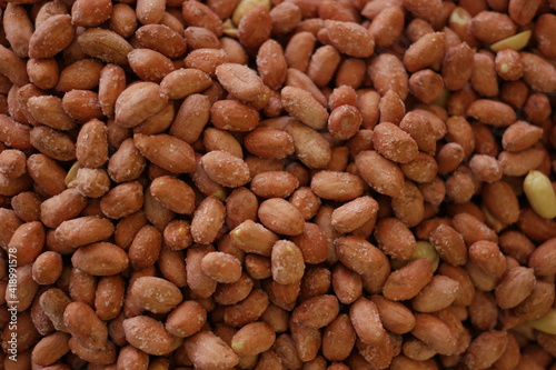 Pile of salted peanuts. Heap of roasted peanuts close up.