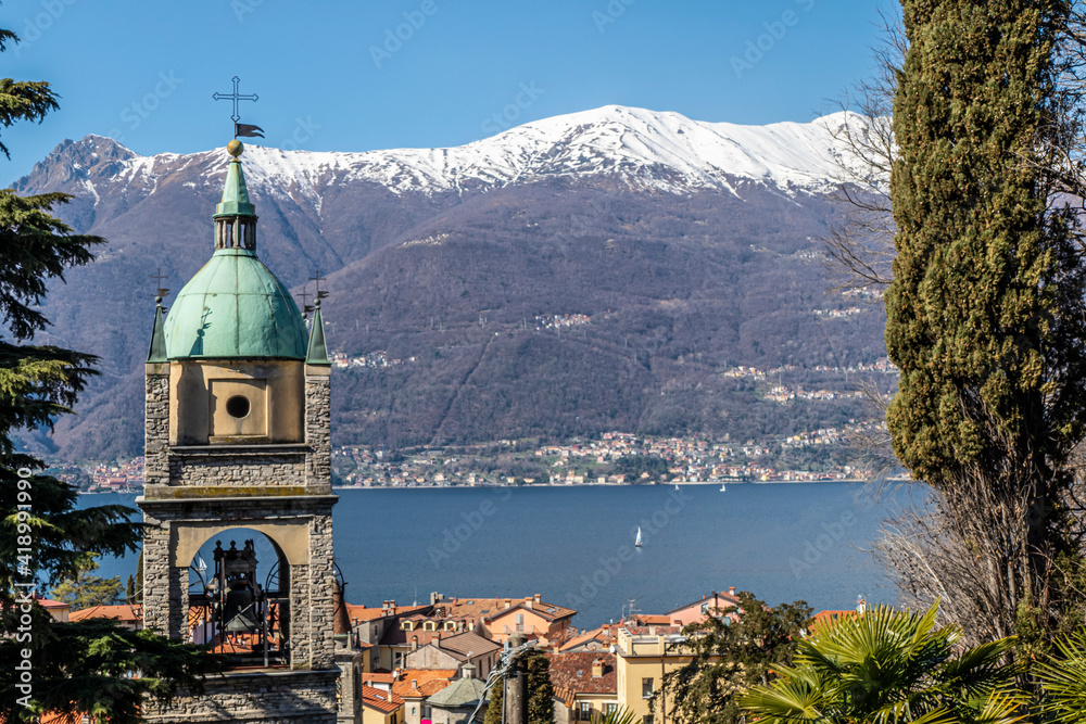 The Bellano stone bell tower with the snow-capped Alps in the background