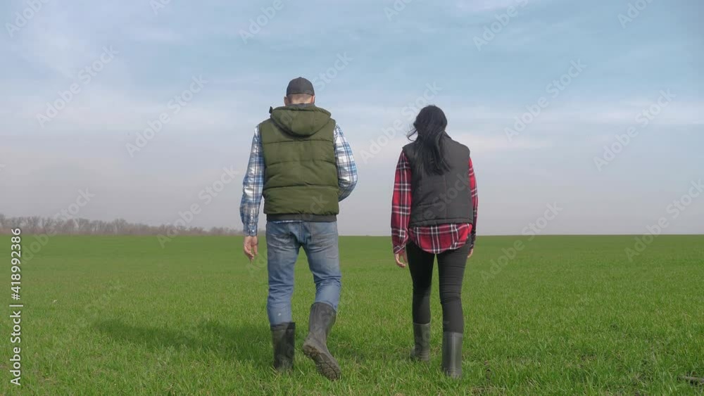 happy family of farmers teamwork a red neck works go on the green field. man and girl farmer are studying eco farming farming harvesting concept. woman and worker lifestyle go walking on agricultural happy family of farmers teamwork a red neck works go on the green field. man and girl farmer are studying eco farming farming harvesting concept. woman and worker lifestyle go walking on agricultural