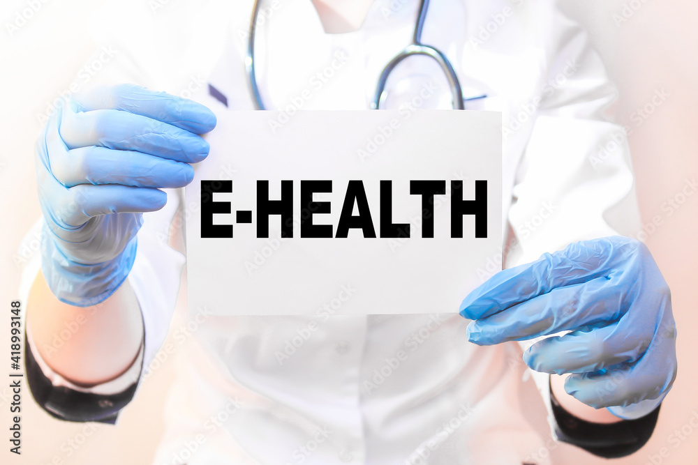 The doctor's blue - gloved hands show the word E-HEALTH - . a gloved hand on a white background. Medical concept. the medicine The doctor's blue - gloved hands show the word E-HEALTH - . a gloved hand on a white background. Medical concept. the medicine