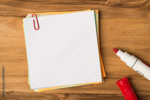 Photo above of empty blank notes paperclips and marker isolated on the wooden background