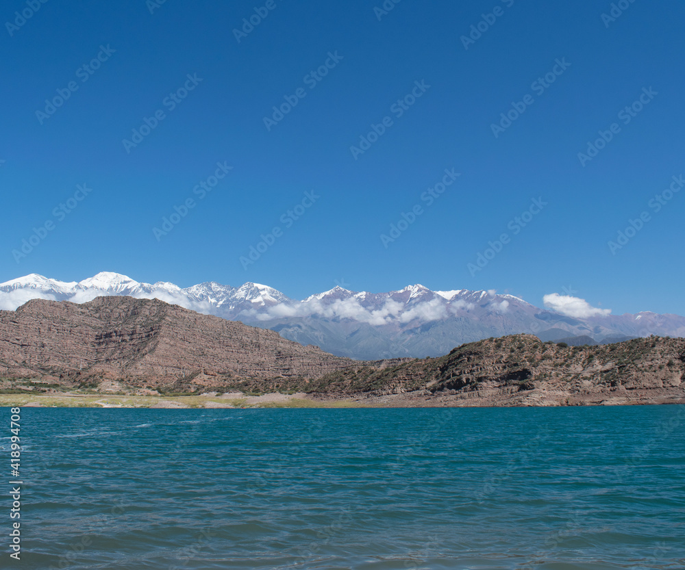 Lago azul con vistas a la cordillera de los Andes argentinos nevados durante el verano