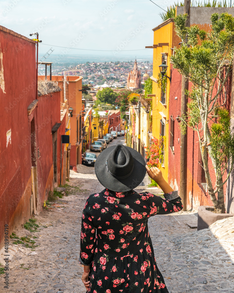 Fototapeta premium Woman in front of colorful street in the colonial city of San Miguel de Allende, Mexico