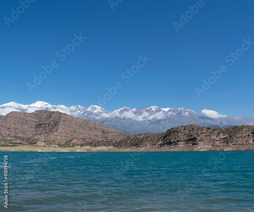 Lago azul con vistas a la cordillera de los Andes argentinos nevados durante el verano