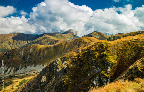 Autumn view of colorful Tatras mountains in Carpatians with cloudy blue sky