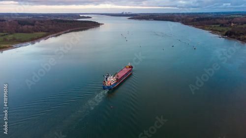 A cargo ship sailing down the River Orwell in Suffolk, UK