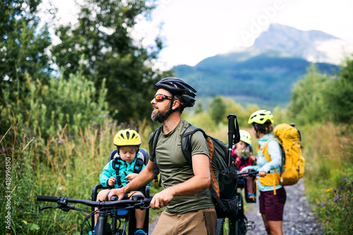 Family with small children with bicycles outdoors in summer nature, High Tatras in Slovakia.