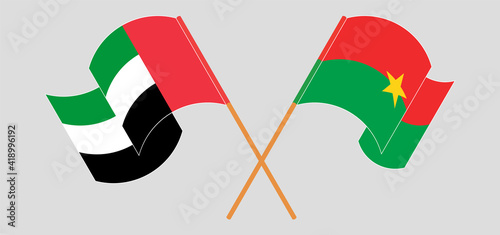 Crossed and waving flags of the United Arab Emirates and Burkina Faso