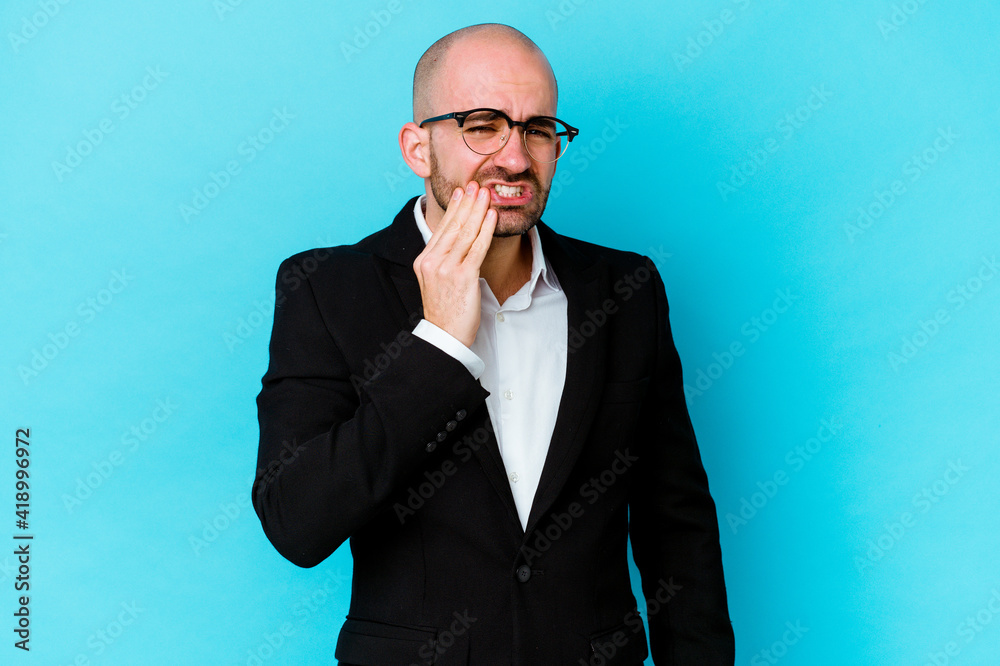 Young business caucasian bald man isolated on blue background having a strong teeth pain, molar ache. Young business caucasian bald man isolated on blue background having a strong teeth pain, molar ache.