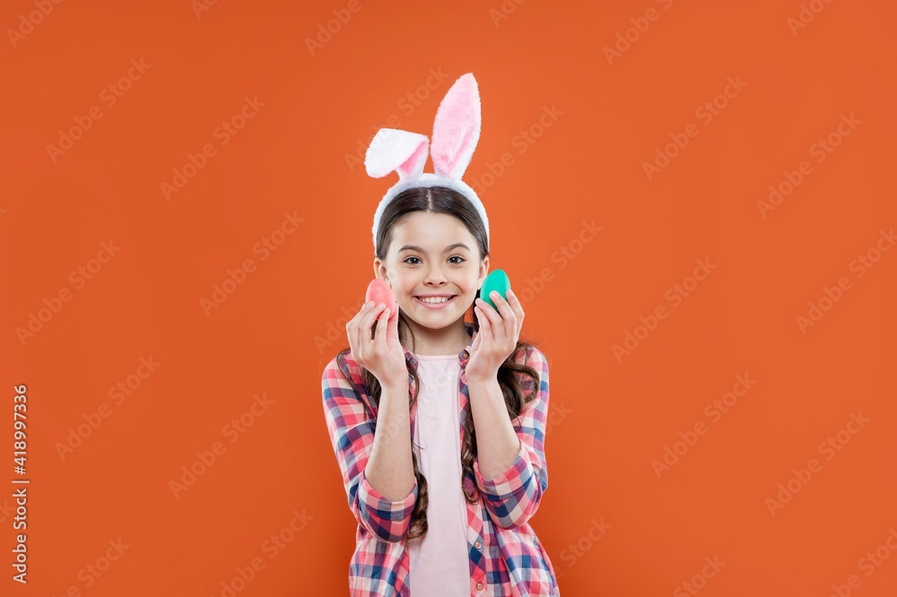 happy child girl in easter bunny ears having fun hold paited eggs, egg hunt