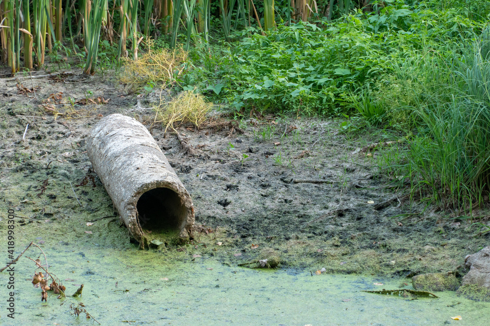 dirty water in the river. Environmental pollution. Construction waste. The asbestos pipe lies on the bank of the river. The world problem of drinking water pollution.