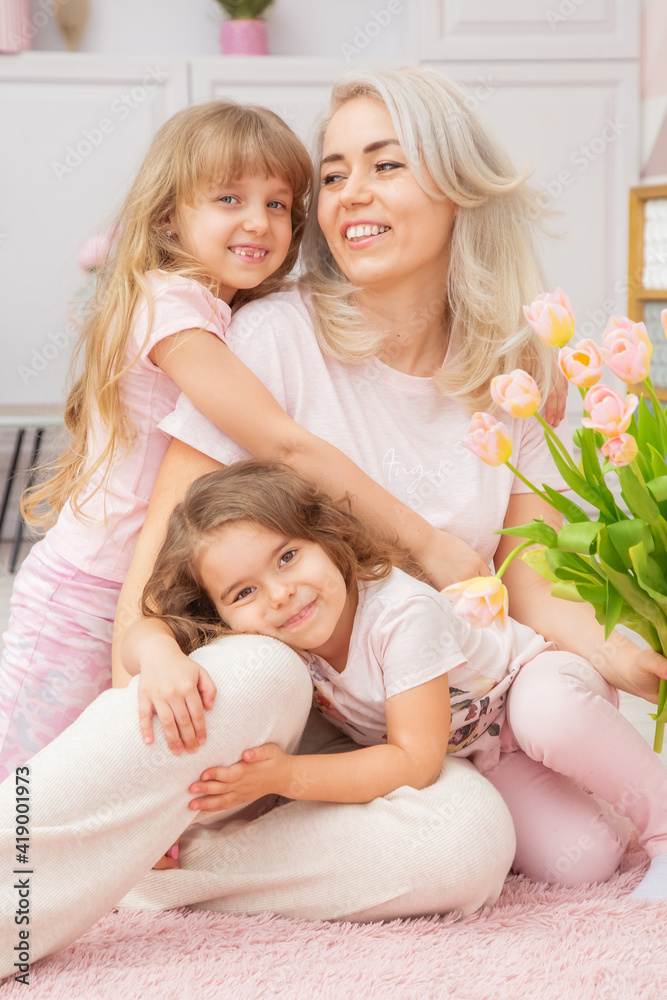 Little girls of Caucasian appearance are hugging with their mother Little girls of Caucasian appearance are hugging with their mother