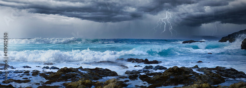 Stormy weather over the night sea coast line with lightning flash and thunder storm and big waves. Thunderstorm ocean. 