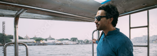 Photography A young man floating on a ship on the river in the city.