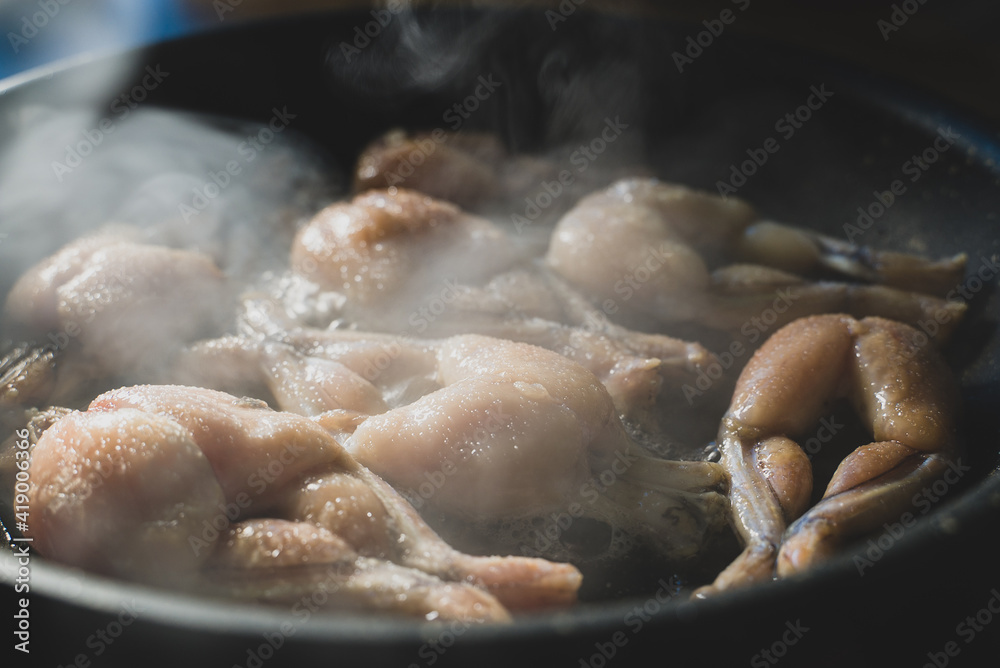 Traditional cooking of fried frog legs on pan. Traditional cooking of fried frog legs on pan.