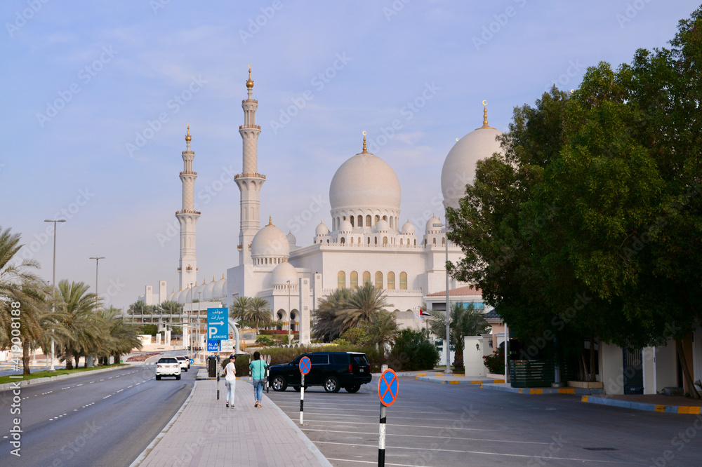 Naklejka premium Sheikh Zayed Mosque against the blue sky and two girls going there