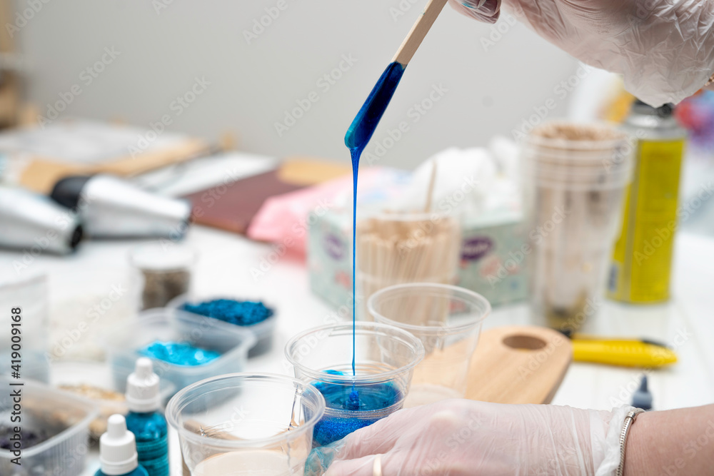 jet of epoxy, painted blue, flowing down into a plastic cup jet of epoxy, painted blue, flowing down into a plastic cup