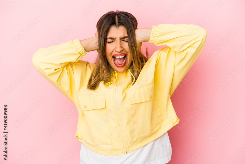 Young indian woman isolated on pink background covering ears with hands trying not to hear too loud sound. Young indian woman isolated on pink background covering ears with hands trying not to hear too loud sound.