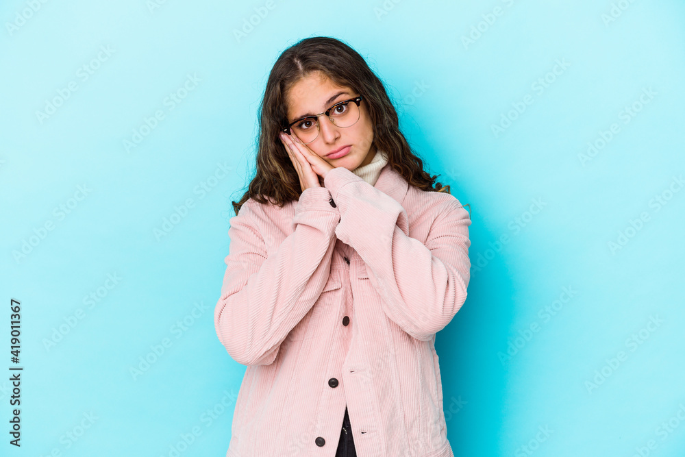 Young caucasian curly hair woman isolated yawning showing a tired gesture covering mouth with hand. Young caucasian curly hair woman isolated yawning showing a tired gesture covering mouth with hand.