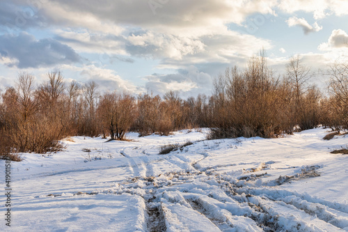 Snow road in spring landscape.