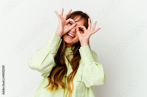 Young caucasian cute woman isolated on white background showing okay sign over eyes