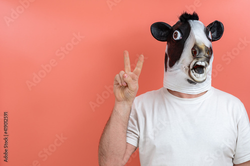 person with cow mask making the victory sign