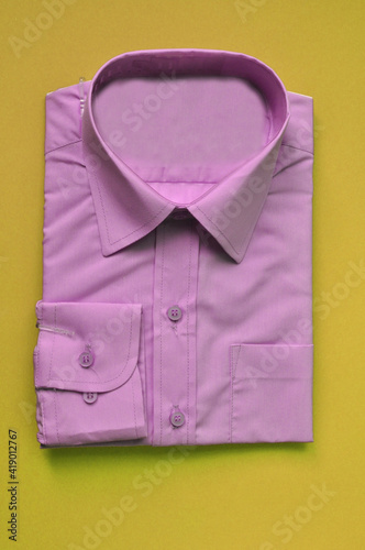 new fabric packed men's violet shirt on a yellow background. Shirt packed for sale. Isolated shirt. Concept wear for bussiness