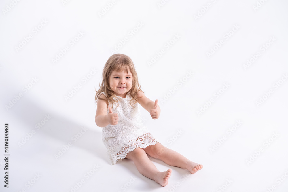beautiful little girl in white dress showing the class sitting on white background beautiful little girl in white dress showing the class sitting on white background