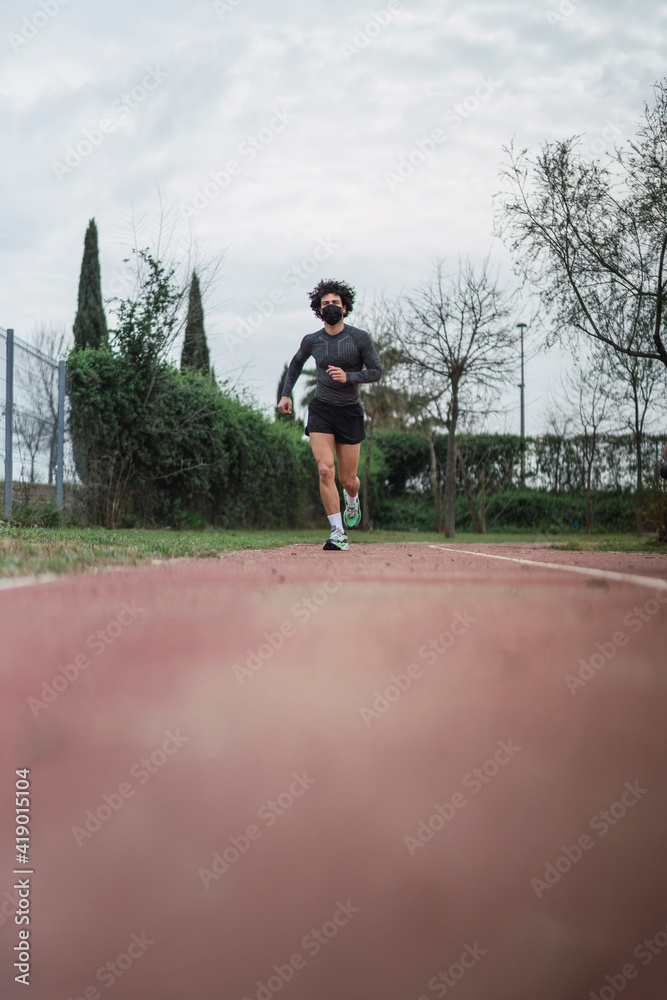 Chico joven con pelo rizado y atletico haciendo deporte Chico joven con pelo rizado y atletico haciendo deporte