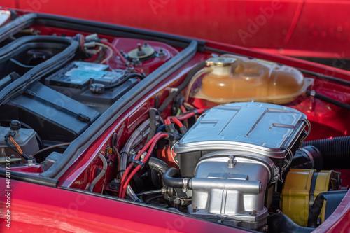 Under the bonnet. Red Italian sport car engine close-up shot. © Zbignev